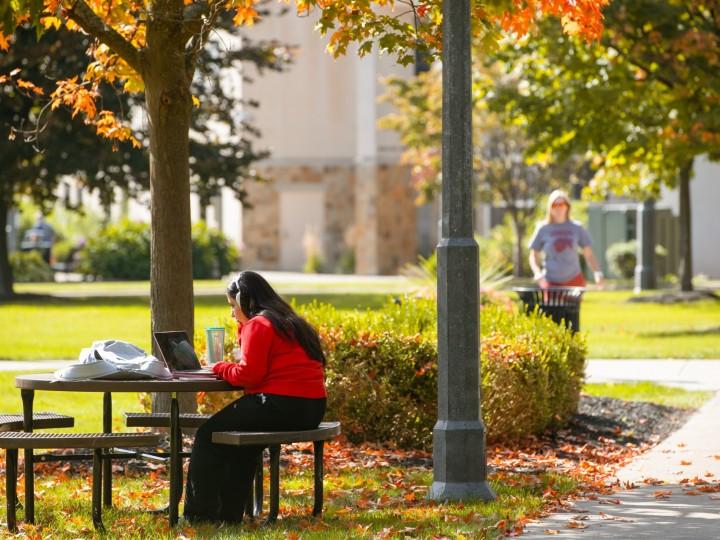 一个学生在外面的桌子旁学习